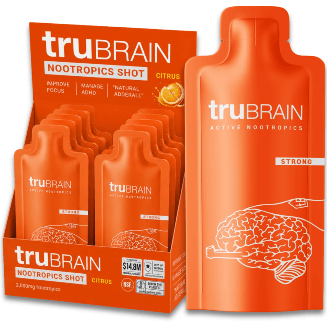 A retail display box and a single large pouch of truBRAIN Nootropics Shot in citrus flavor, shown on a clean white background. The packaging is bright orange with white text and a white brain illustration.