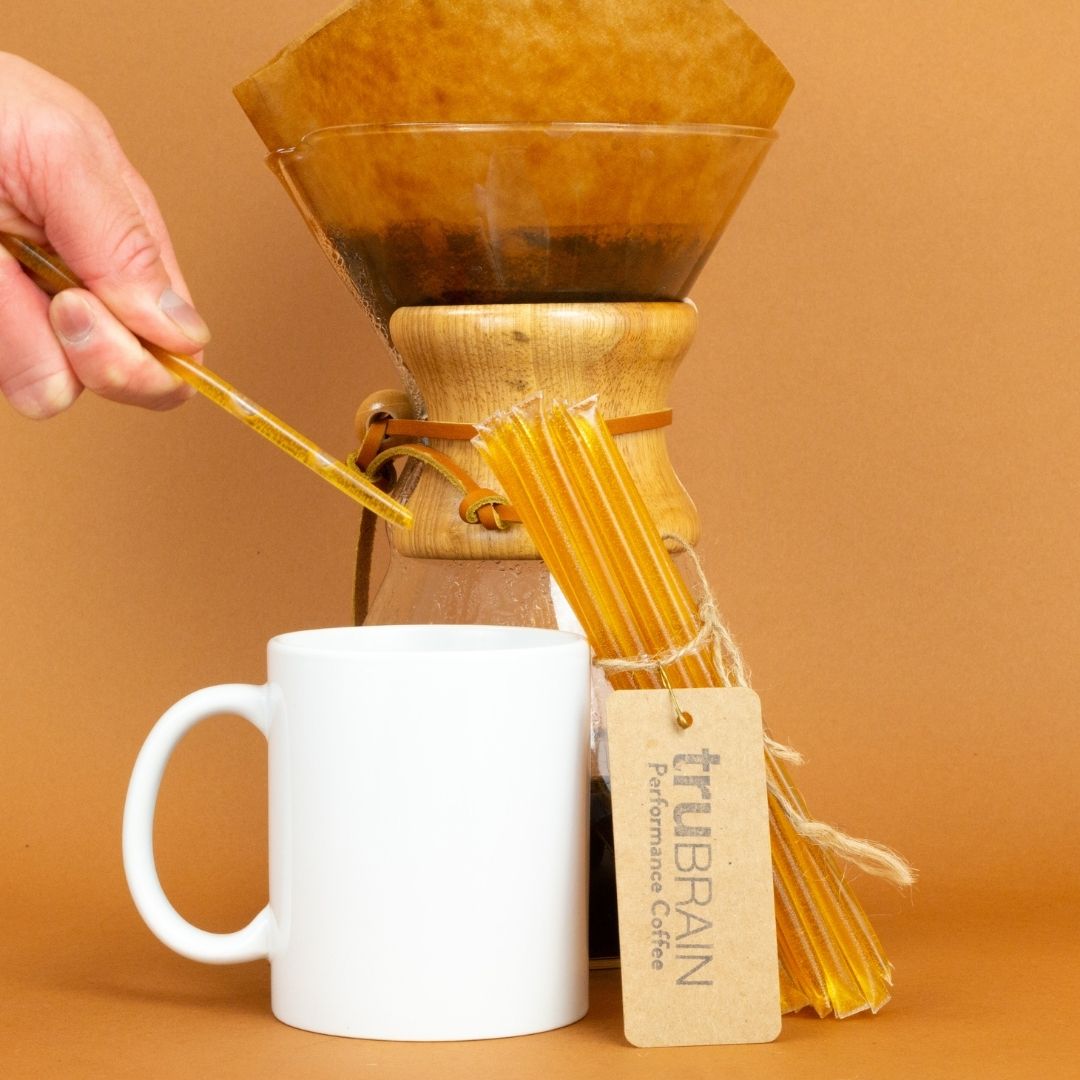 Closeup of the Focus Sticks in TruBrain’s Coffee kit next to a piping hot cup of coffee to evoke an aspirational coffee experience of being sharp, but not shaky